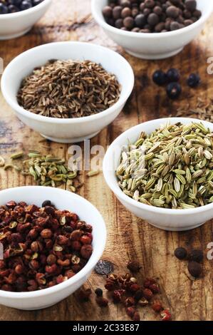 Various Spices In Small White Bowls On A Wooden Background Stock Photo