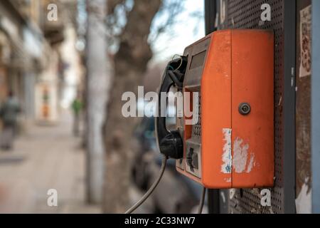 old red pay phone on city street. Stock Photo