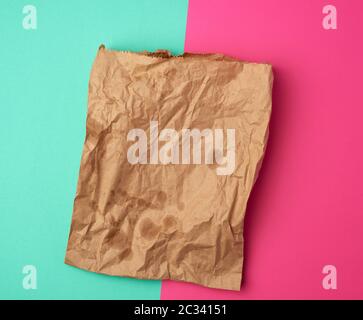 open brown paper bag for food packaging with greasy stains on a pink green background, concept of rejection of plastic bags to save the environment Stock Photo