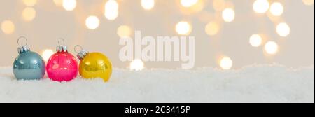 many different christmas items on white snow with many small, shining lights in the background Stock Photo