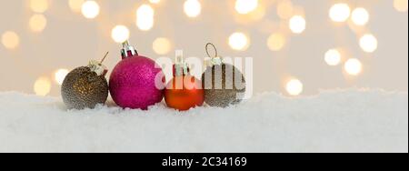 many different christmas items on white snow with many small, shining lights in the background Stock Photo