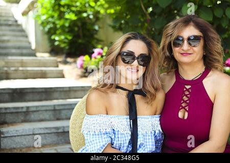 Middle age woman with her adult daughter wearing hat Stock Photo