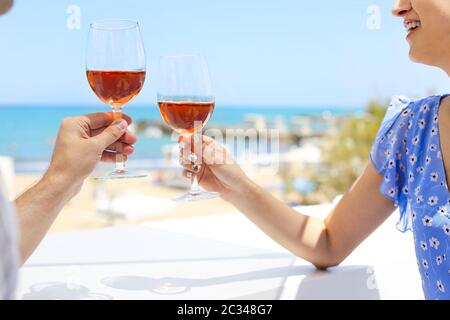 Hands of couple enjoying glasses of rose wine on tropical beach Stock Photo