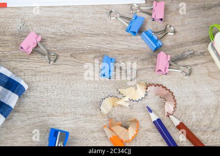 Pencil sharpening shavings and a few pencils on a wooden table. Stock Photo