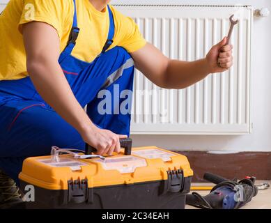 Young repairman contractor repairing heating panel Stock Photo
