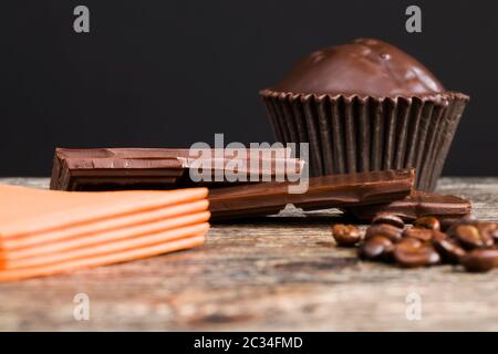 beautiful roasted coffee beans composed in the form or sign near the brown chocolate cake on wooden table Stock Photo
