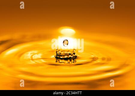 Closeup on drop of cosmetic golden oil liquid. Stock Photo