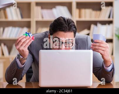 Businessman gambling playing cards at work Stock Photo