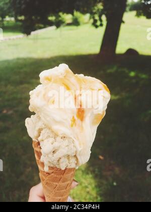 Ice cream cone melting outdoors in summer, sweet dessert food on holiday Stock Photo