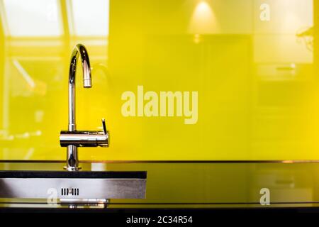 Modern stainless steel faucet and sink near poisen green wall, retro design beauty luxury Stock Photo