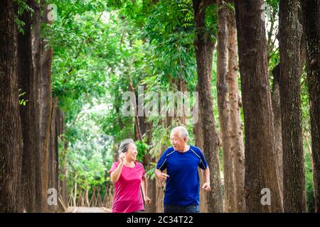 happy asian senior couple jogging together at morning Stock Photo