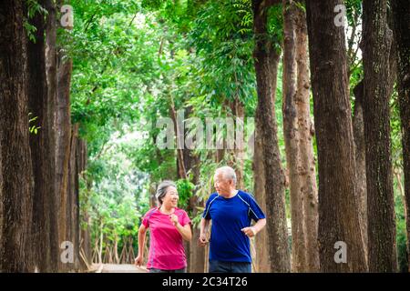 happy asian senior couple jogging together at morning Stock Photo