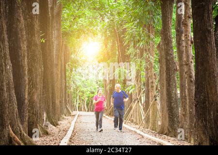 happy asian senior couple jogging together at morning Stock Photo