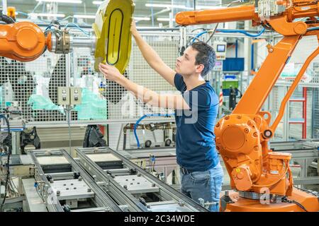 setting up a robotic line with automatic arms before starting the process. Stock Photo