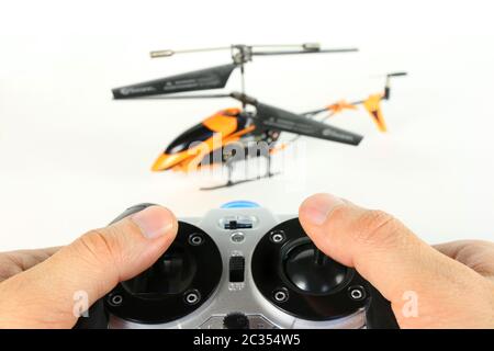 Guy playing with remote helicopter with radio remote control isolated on white Stock Photo