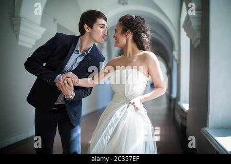 Happy couple playfully goes down a long corridor Stock Photo