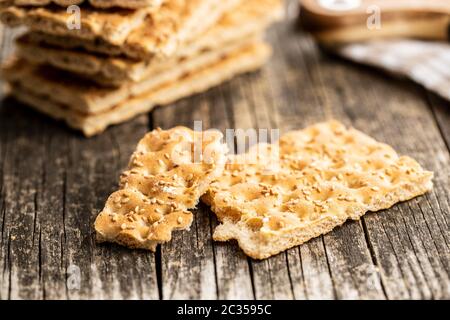Knackebrot. Wholegrain crispbread with sesame seeds on old wooden table. Stock Photo