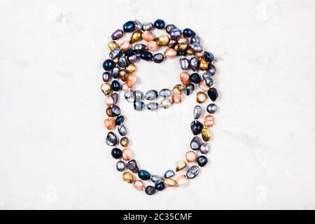 handmade necklace from various river pearls on gray concrete background Stock Photo