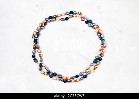 top view of hand crafted necklace from colored river pearls on gray concrete background Stock Photo
