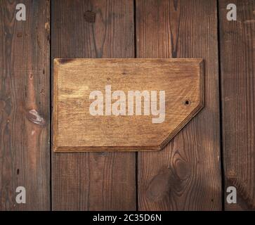 very old empty wooden rectangular cutting board, top view, brown wooden background Stock Photo