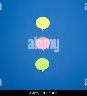 multicolored empty paper stickers in the form of clouds on a blue background, copy space Stock Photo