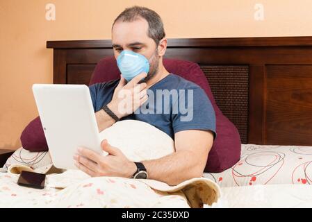 ill man using tablet in the bed. Stock Photo