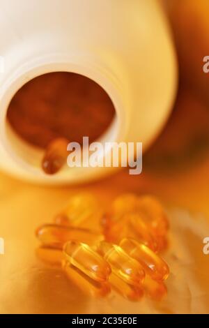 Fish Oil Gelatin Capsules on packaging blurred background.Omega three fatty acids.Healthy eating and lifestyle concept. Stock Photo