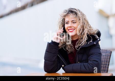 Beautiful cacuasian woman with smartphone. Girl Blonde curly hair with copy space for text Stock Photo