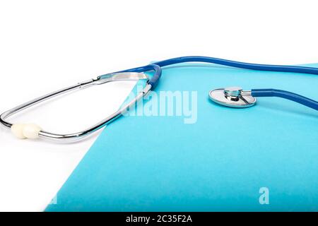 medical record and blue stethoscope close-up on white background in studio Stock Photo