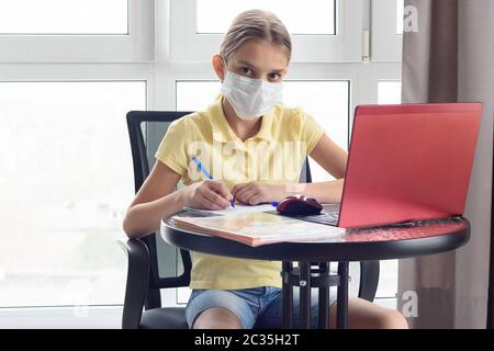 A sick quarantined girl remotely learns and looked in frame Stock Photo