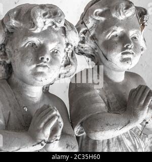 Statues of children in prayer Stock Photo