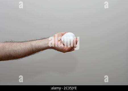 Man Holding Snowball in Hairy Hand Stock Photo