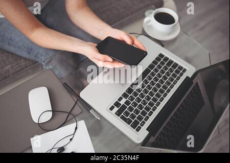 Female hands using smart phone in interior workplace, freelance business woman using cell phone at office desk, working from home using smart phone Stock Photo