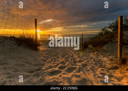 entrance to a sandy beach during a beautiful sunset Stock Photo