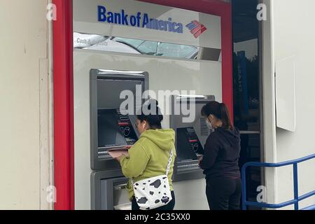 Women at an automatic teller machine at Bank of America amid the