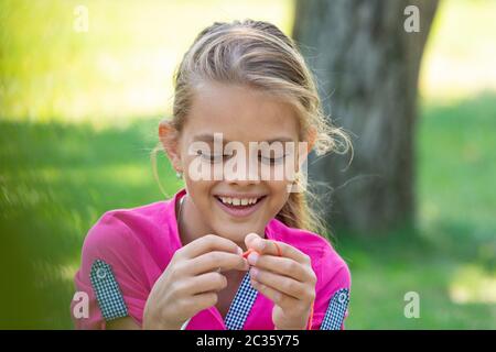 Portrait of a girl who knits on a knitting needles on a picnic in nature, close-up Stock Photo