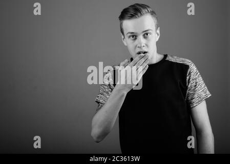 Young handsome man with blond hair against gray background Stock Photo