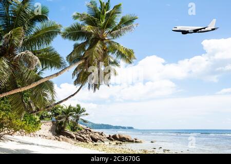 Airplane Is Flying In Cloudy Sky Over Island And Sea In Summer At Seychelles Stock Photo