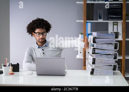 Businessperson Pushing Paper Documents Away And Working With Digital Documents On Computer Instead Stock Photo