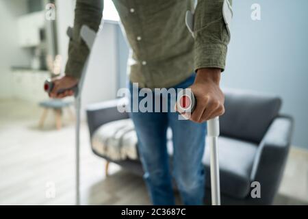 Disabled Man Using Crutches For Walking On Floor Stock Photo