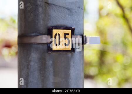 the number five on a metal tray with green bokeh in the background Stock Photo