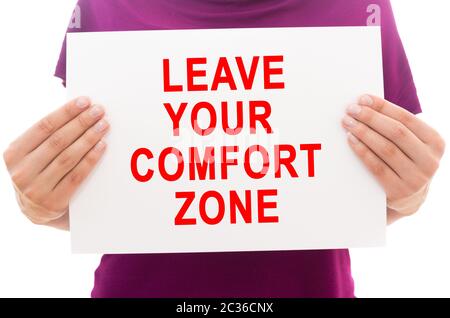 Girl holding white paper sheet with text Leave your comfort zone Stock Photo