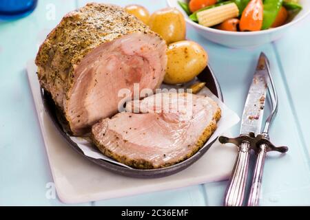 Mustard and herbs pork lion with baby potatoes and vegetables Stock Photo