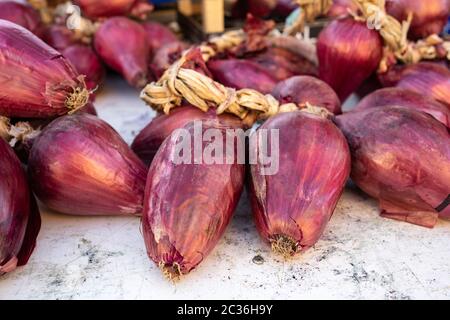 Red onions from Tropea (cipolla rossa di Tropea) at a farmers market in Italy Stock Photo
