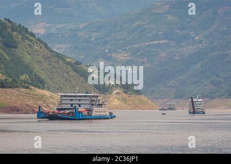 Yangtze River, China - August 2019 : Cargo ship ship transporting trucks and other vehicles sailing through the gorge on the magnificent Yangtze River Stock Photo