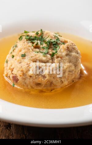single speckknoedel in soup on wood Stock Photo
