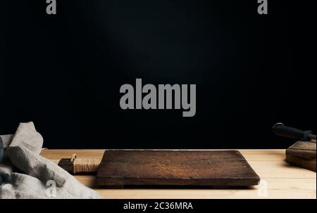 very old empty wooden rectangular cutting board, black background Stock Photo