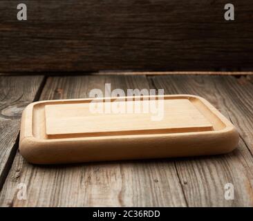 light beige rectangular empty cutting kitchen board on a wooden background from old boards, top view Stock Photo