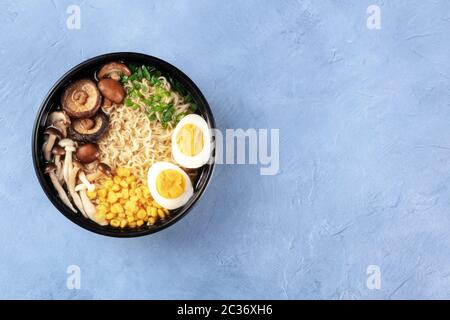 Ramen noodle soup. Soba with eggs, shiitake and enoki mushrooms, and vegetables, overhead shot with copyspace Stock Photo