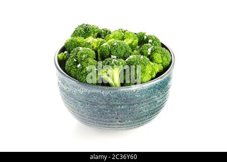 A bowl of cooked broccoli with salt on a white background Stock Photo
